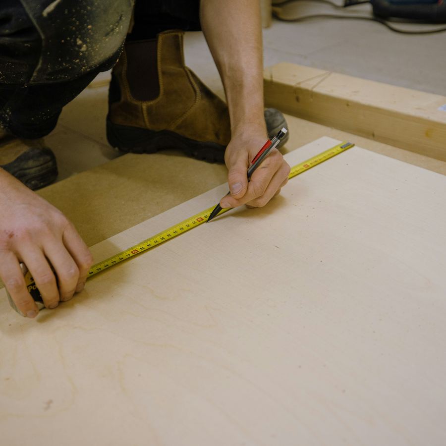 A handyman measuring timber